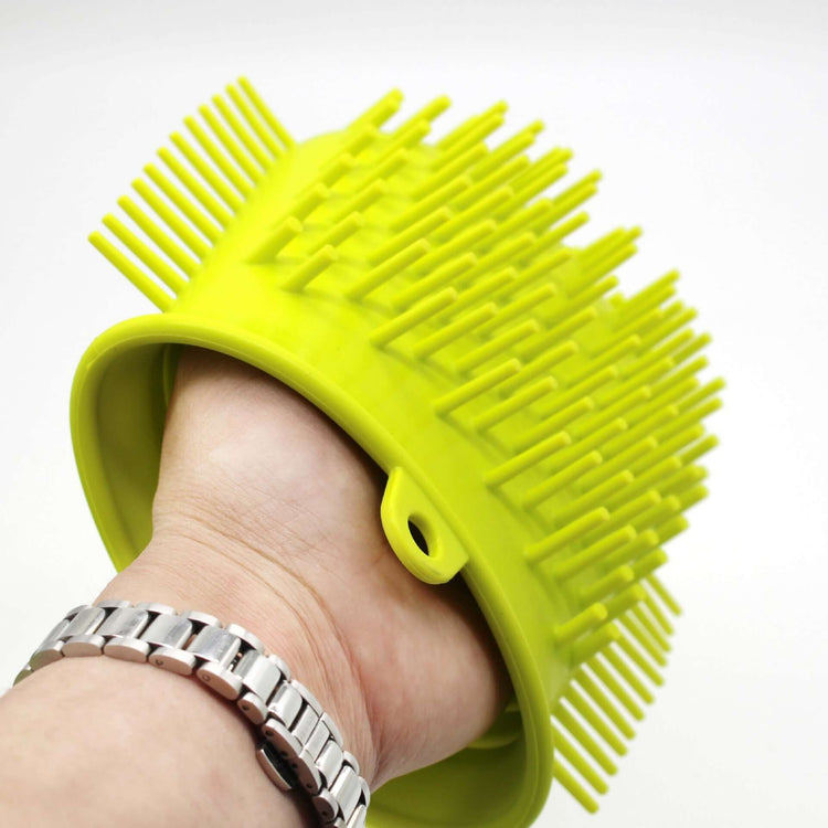 Portable dog paw cleaner in hand, featuring a bright yellow design with bristles for effective pet cleaning.