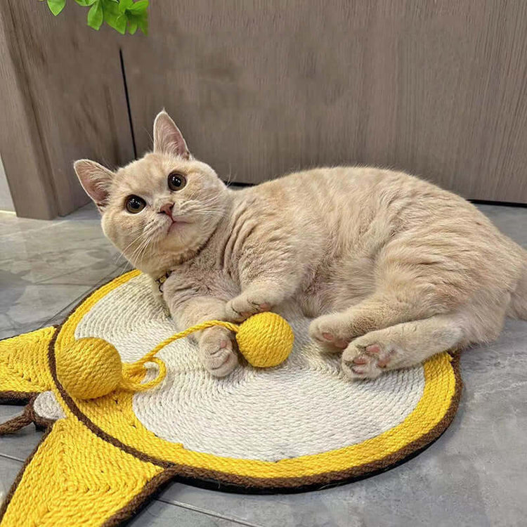 Cute cat lounging on a sisal cat scratching mat with a playful yellow ball, showcasing the durable design and natural materials.