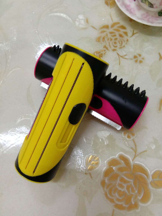 Pet grooming brush for dogs and cats displayed on a floral table surface, featuring a yellow and pink design.