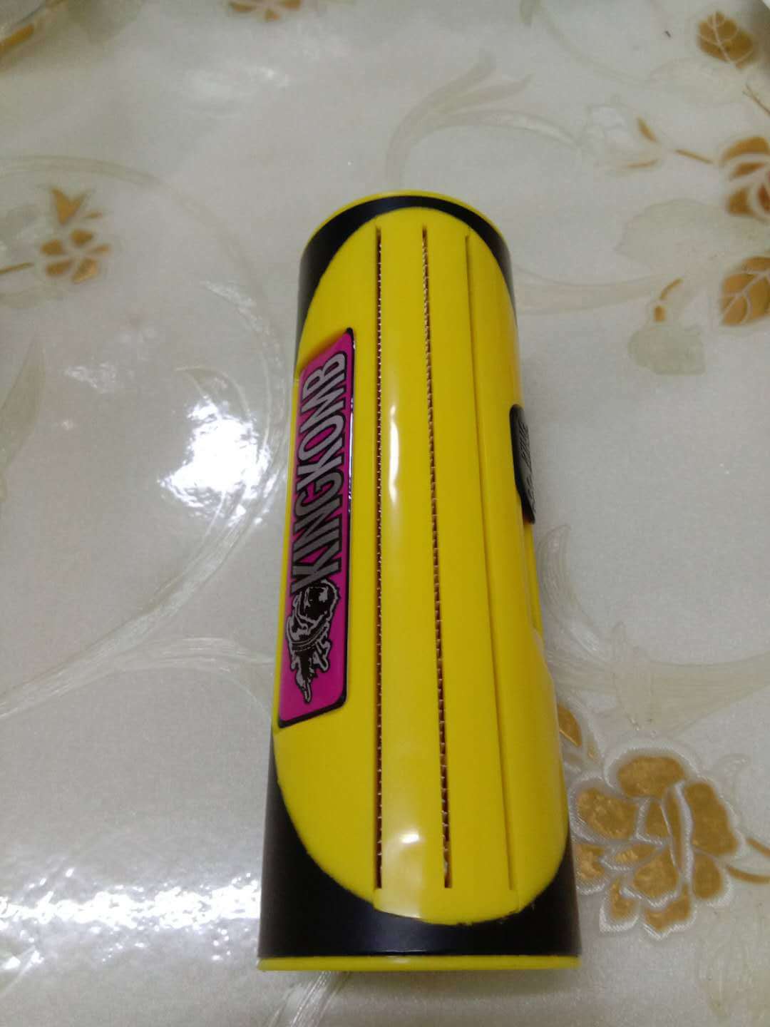 Yellow pet grooming brush for dogs and cats, practical cleaning accessory, shown on a glossy surface.