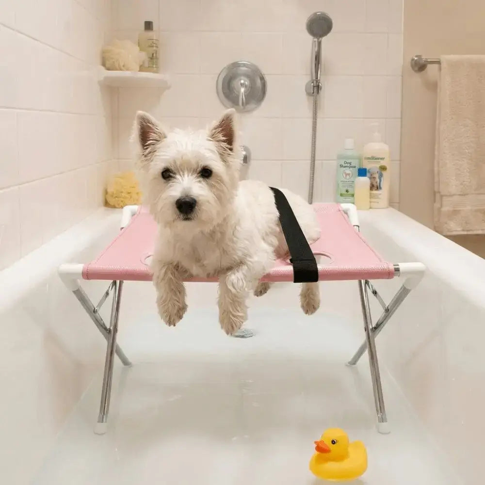 Foldable pet grooming table supporting a small white dog in a bathtub with a rubber duck.