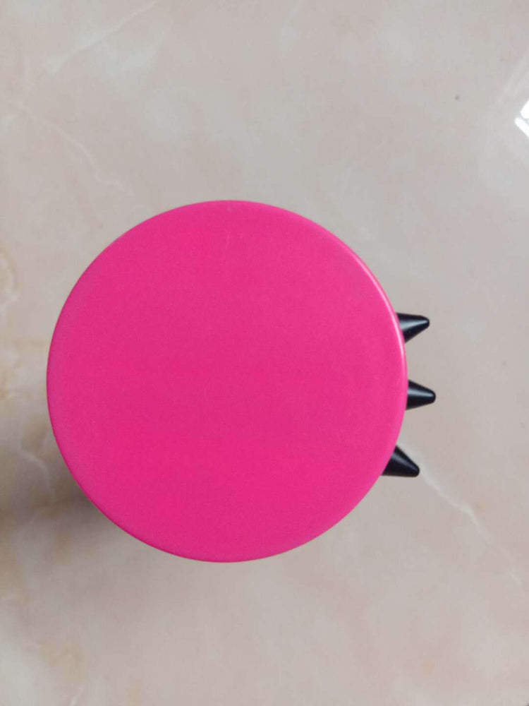 Top view of a pink pet grooming brush for dogs and cats with black spikes, a practical cleaning accessory.