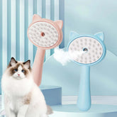 Steam cleaning grooming brush for cats in pink and blue, with a fluffy cat in the foreground.